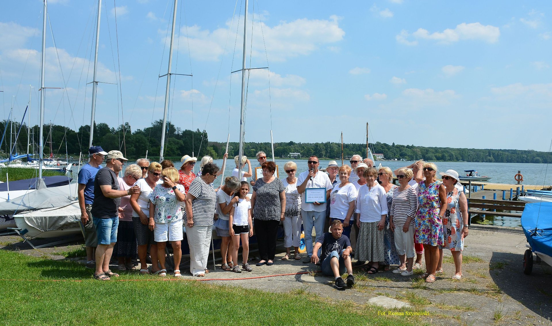 Wyjazdowe posiedzenie MRS (Kiekrz, 17.06.2021), na zdjęciu grupa seniorów, w tle jezioro, łódki