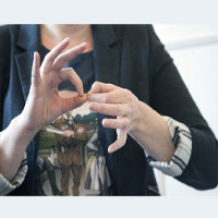 Dłonie kobiety, które pokazują jeden ze znaków w polskim języku migowym
