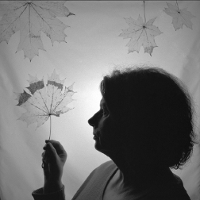 Jedna z prac uczestników, czarno-biała fotografia przedstawiająca portret kobiety z profilu trzymającej w dłoni liść.