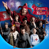 na zdjęciu grupa osób w kostiumach historycznych z różnych okresów, za nimi widoczna największa postać - Stańczyk w czerownym stroju błazna