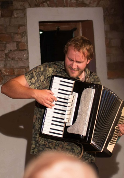 Na zdjęciu mężczyzna grający na akordeonie.