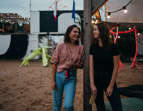 Zdjęcie przedstawia dwie uśmiechnięte osoby. W tle KontenerArt.