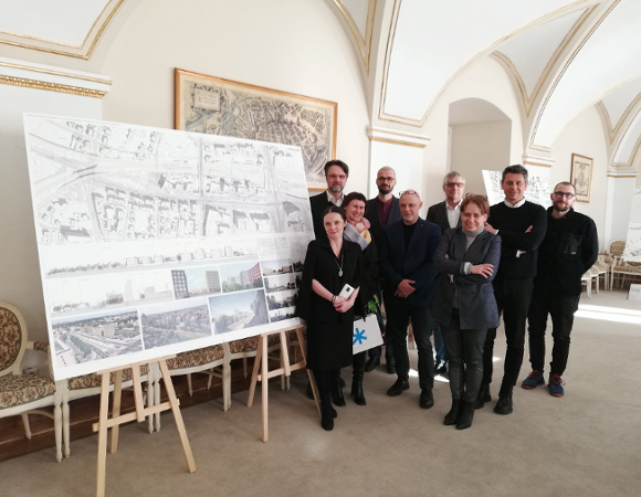 Zdjęcie przedstawia jury konkursu stojące przy jednej z wydrukowanych prac