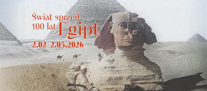 Zdjęcie przedstawia sfinksa. Przed nim na wielbładzie siedzi mężczyzna. W tle widać piramidę. Zdjęcie ma wyblakłe kolory.