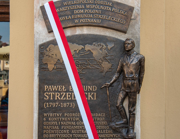 Zdjęcie ukazuje tablicę poświęconą Pawłowi Edmundowi Strzeleckiemu na fasadzie Domu Polonii.