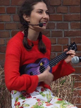Zdjęcie kobiety grającej na ukulele.