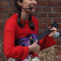 Zdjęcie kobiety grającej na ukulele.