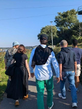 Grupa ludzi spacerująca wśród zieleni.