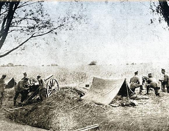 Zołnierze obok namiotu, armaty i karabinu maszynowego.