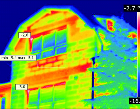Zdjęcie przedstawia obraz budynku wygerenrowany przez kamerą termowizyjną, na którym widać mostki cieplne, czyli miejsca, najbardziej narażone na utratę energii.