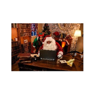 Mikołaj i Elf przy laptopie. W tle kominek. Po lewej regał z książkami.