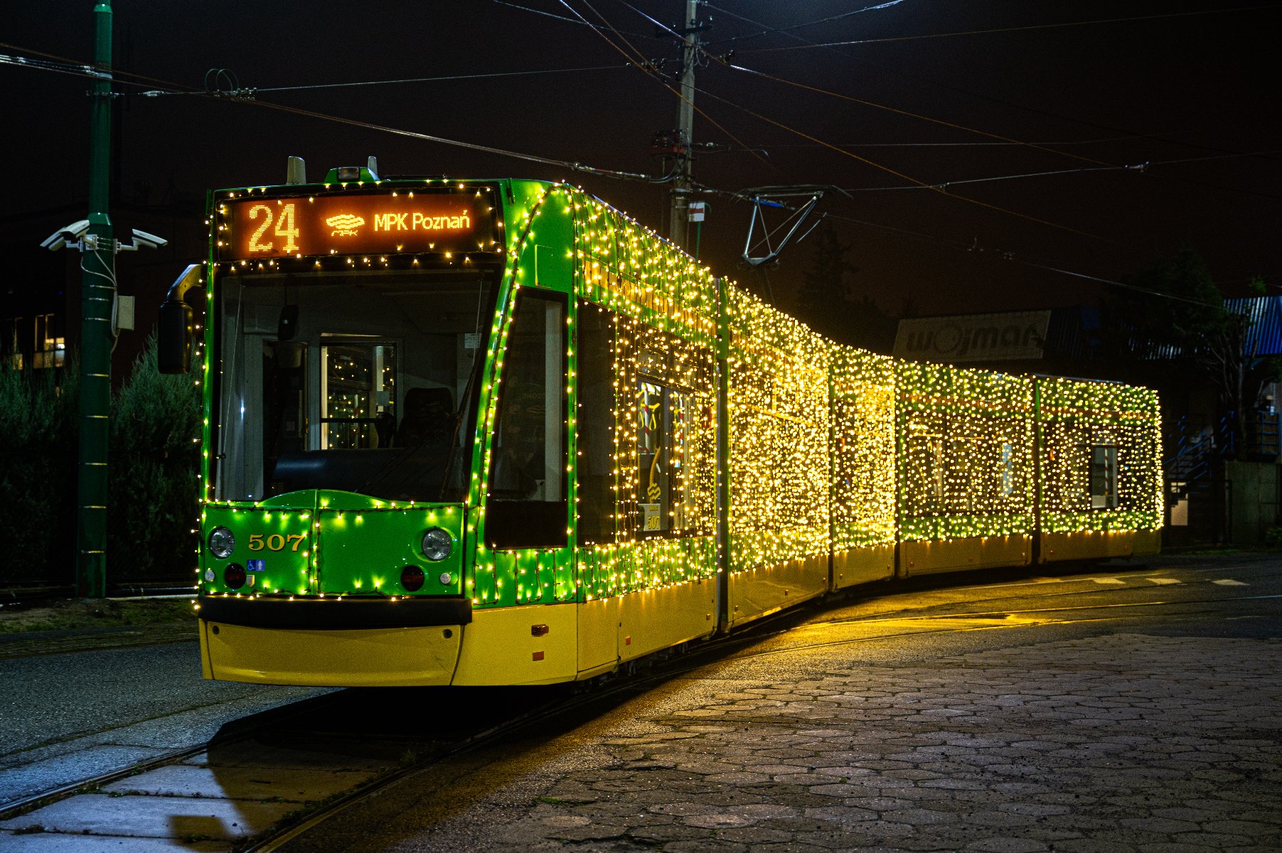 Zielony tramwaj oświetlony świątecznymi lampkami - grafika artykułu