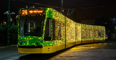 Zielony tramwaj oświetlony świątecznymi lampkami