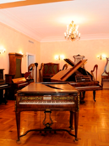 Na zdjęciu wnętrze muzeum. Na pierwszym planie klawesyn. W tle inne instrumenty muzyczne.