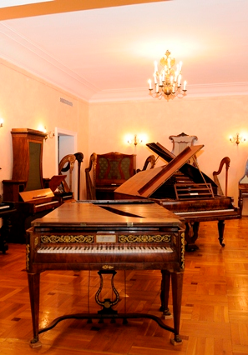 Na zdjęciu wnętrze muzeum. Na pierwszym planie klawesyn. W tle inne instrumenty muzyczne.