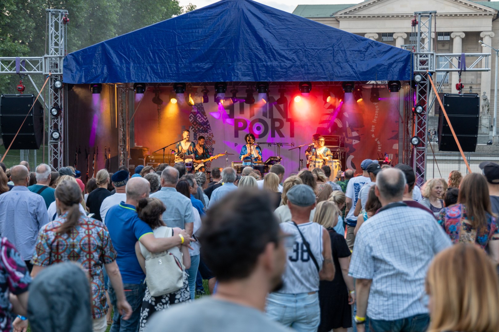 Już po raz 18. w sercu Poznania rozbrzmi muzyka z różnych stron świata, a przestrzeń Centrum Kultury Zamek i sąsiadujący z nim park Adama Mickiewicza wypełnią się kolorami/ materiały prasowe Zdjęcie przedstawia artystów na scenie i tłum ludzi pod sceną.